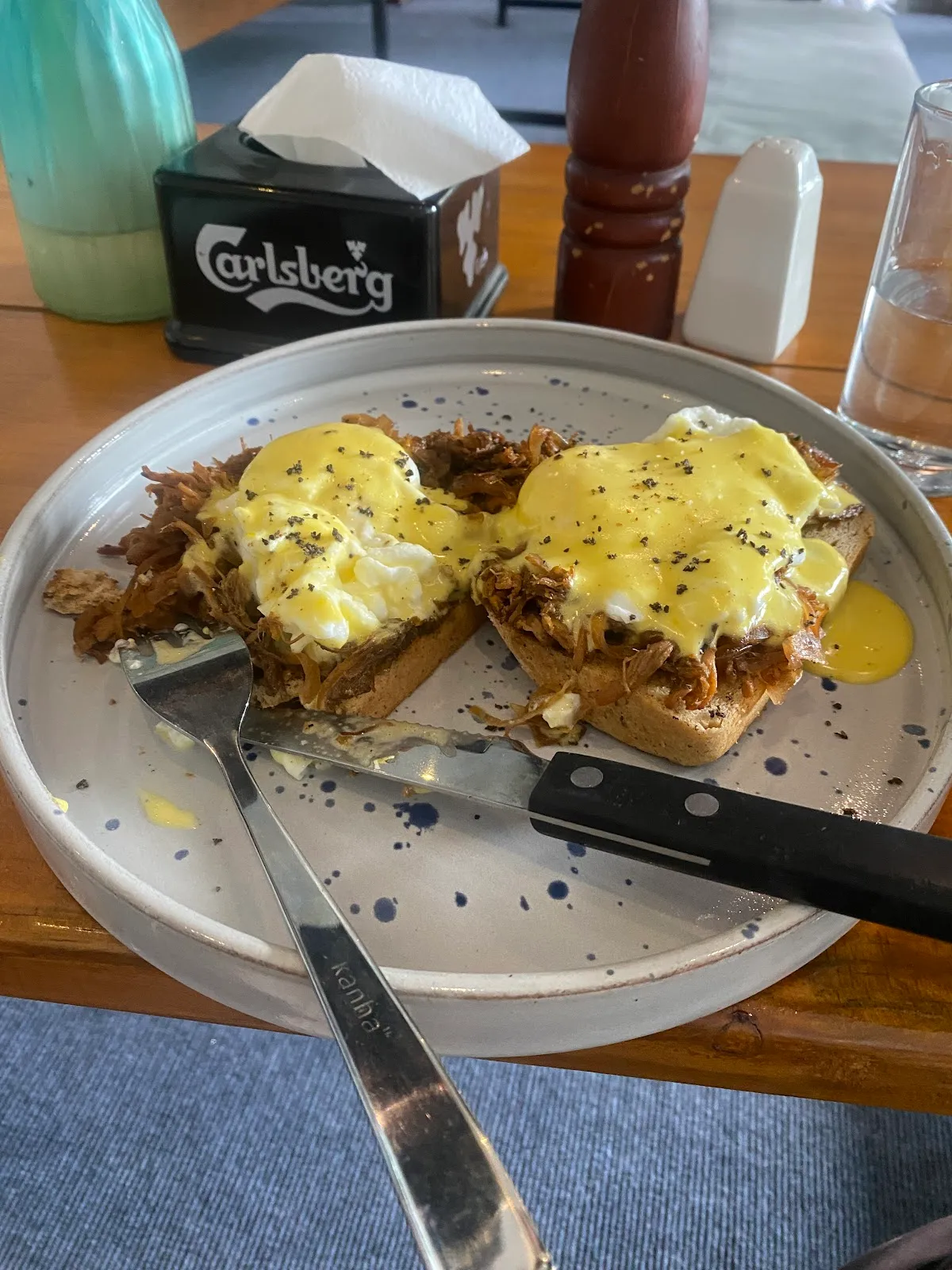 Eggs Benedict with pulled pork and yellow hollandaise on toasted bread